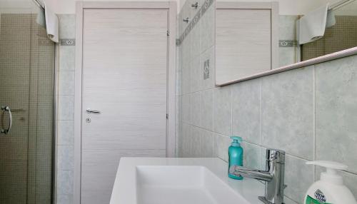 a bathroom with a sink with a blue bottle on it at GUEST HOLIDAY BARI in Reggio Emilia
