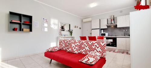 a red couch in a room with a kitchen at GUEST HOLIDAY BARI in Reggio Emilia