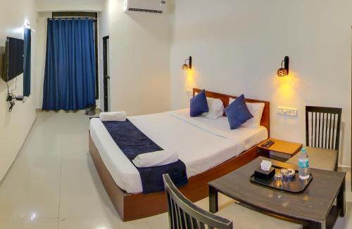 a hotel room with a bed and a table with a table at HOTEL RAIN SKY INN in Lonavala