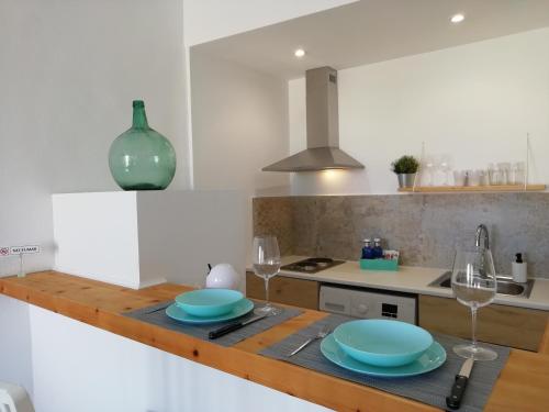 une cuisine avec des plaques bleues et des verres sur un comptoir dans l'établissement El nido de Betlem, à Colònia de Sant Pere