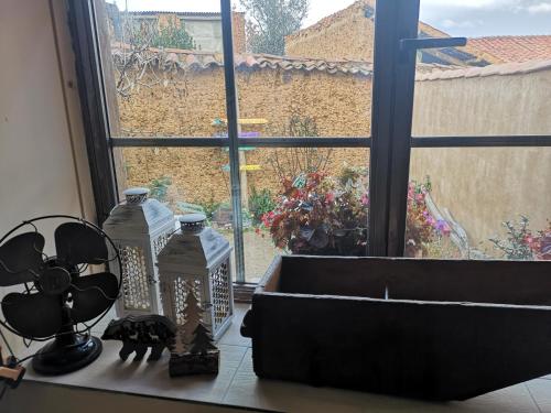 a window with two glass bottles on a counter at L' Abilleiru Albergue Rural in Santibáñez de Valdeiglesias