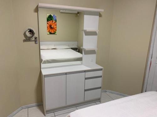 Habitación pequeña con cama y mostrador blanco en Res. Acapulco, en Bombinhas