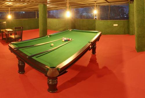 a green pool table on a red floor in a room at Hotel Rain Sky Inn in Lonavala