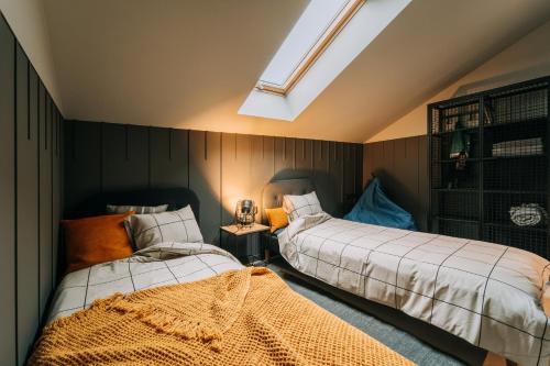 a bedroom with two beds and a skylight at Apartamenty Riders Lodge Szczyrk Kalinowa in Szczyrk