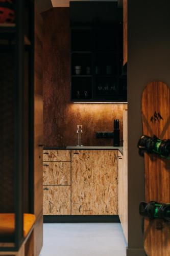 a kitchen with wooden cabinets and a sink at Apartamenty Riders Lodge Szczyrk Kalinowa in Szczyrk