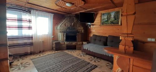 ein Wohnzimmer mit einem Sofa und einem Kamin in der Unterkunft Wood-House in Tatariw