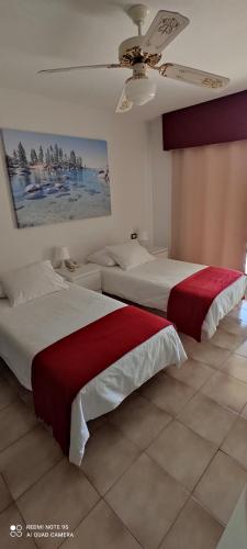 sypialnia z dwoma łóżkami i obrazem na ścianie w obiekcie Castle HARBOUR 425 w mieście Los Cristianos