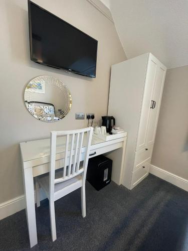 a white desk with a white chair and a mirror at Ivy Bank Guest House, Tenby in Tenby