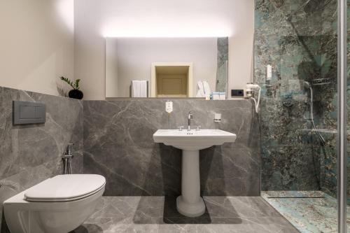 a bathroom with a toilet and a sink and a shower at Maestral in Lviv