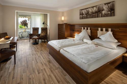 a bedroom with a large bed with a wooden headboard at Aparthotel Christine in Bad Füssing