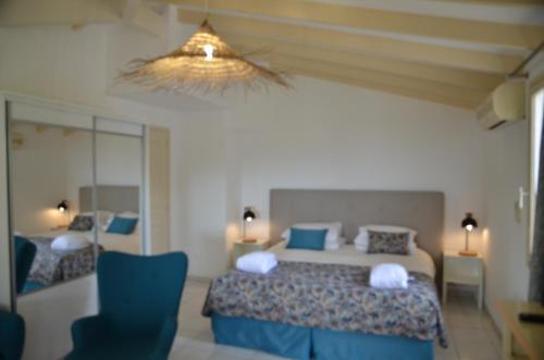 une chambre avec un lit avec des oreillers bleus dans l'établissement Santa Giulia - Le village de L'hacienda, à Porto-Vecchio