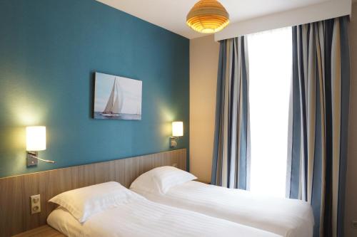 - une chambre avec 2 lits et un voilier sur le mur dans l'établissement Villa des Thermes, à Saint-Malo