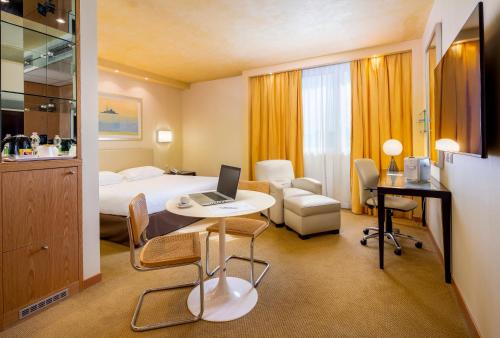 a hotel room with a bed and a desk with a laptop at Crowne Plaza Padova, an IHG Hotel in Padova