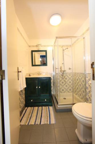 a bathroom with a sink and a shower at Casa do Ribeirinho in Porto Moniz