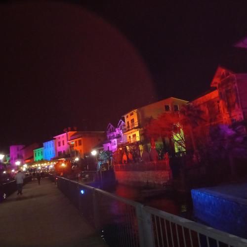 a group of buildings with colorful lights at night at Casa Fiorita 22 Porto Ceresio in Porto Ceresio