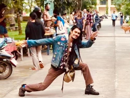a woman is dancing on a city street at Good Life Dacha Wellness Homestay in Pai