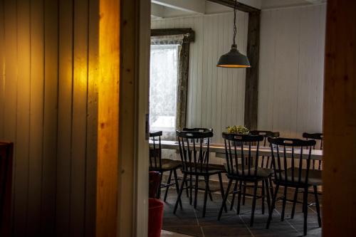 a dining room with a table with black chairs at Villa Vengetind in Isfjorden