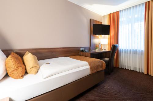 a hotel room with a bed and a desk at Hotel im Park in Haan