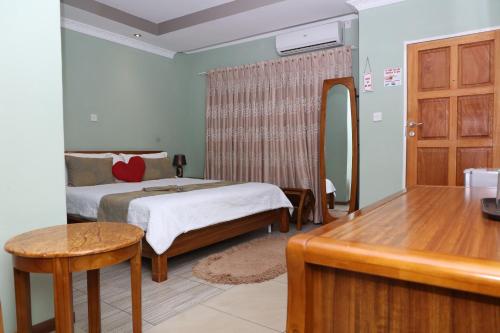 Schlafzimmer mit einem Bett, einem Tisch und einem Spiegel in der Unterkunft gaThuli Guest House in Kanye