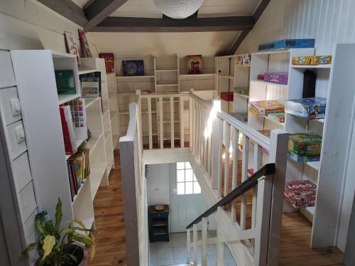 eine Treppe in einem Haus mit weißen Regalen in der Unterkunft Maison Landaise chaleureuse in Rion-des-Landes