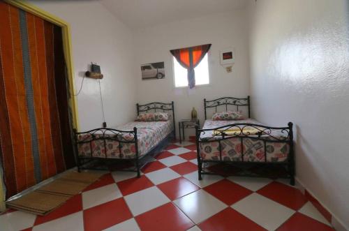 薩菲的住宿－Ait Mouli Surf House，一间卧室设有两张床,铺有一个 ⁇ 板地板