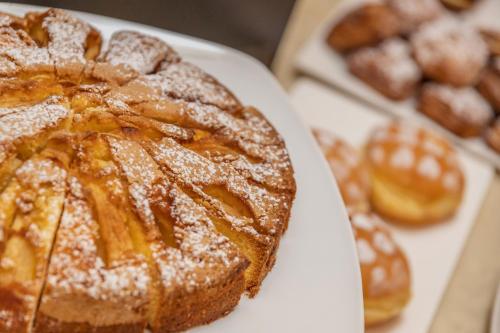a pastry on a white plate with other pastries at Pippo Hotel in Terzolas