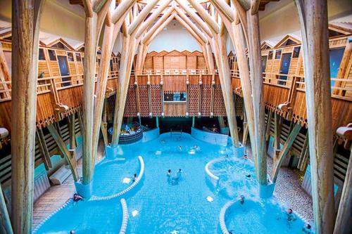 a large indoor swimming pool in a building at Les Granges de La hulotte, la hulotte in Lies
