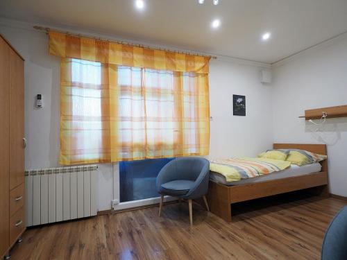 佩奇的住宿－Pajger Apartman，卧室配有床、椅子和窗户。
