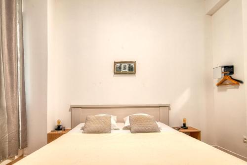 une chambre avec un grand lit blanc avec deux oreillers dans l'établissement SUITE STALINGRAD, à Nice