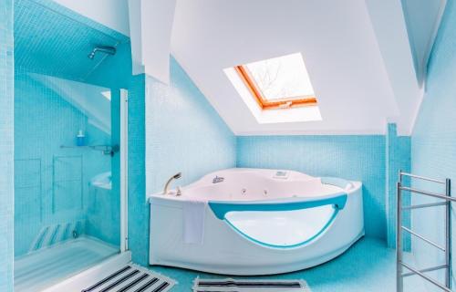 een blauwe badkamer met een bad en een douche bij Suites Foz O Porto in Porto