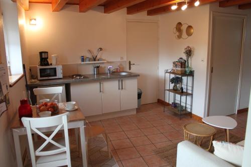 une petite cuisine avec une table et un micro-ondes dans l'établissement Gîtes chez l'habitant La Touche d'en Bas, à Plouguenast Langast