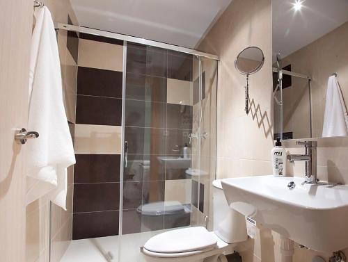 a bathroom with a shower and a toilet and a sink at Pensión Herradores in Soria