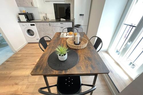 uma mesa de madeira com cadeiras numa cozinha em Le Petit Nid WifiNetflix LongchampGare SCNF em Marselha