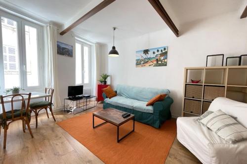 uma sala de estar com um sofá e uma mesa em Le Méditerranéen T2 WifiNetflix CityCenter em Marselha