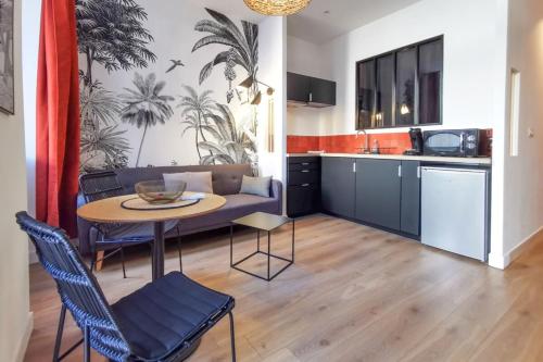 une cuisine et un salon avec une table et des chaises dans l'établissement Bain de Soleil ! Terrasse Clim Wifi Netflix, à Marseille