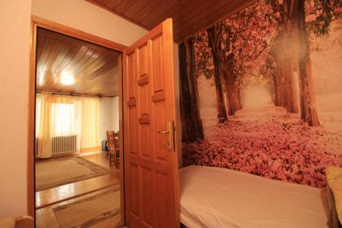 a bedroom with a bed and a wall with flowers at Apartman Luka in Jahorina