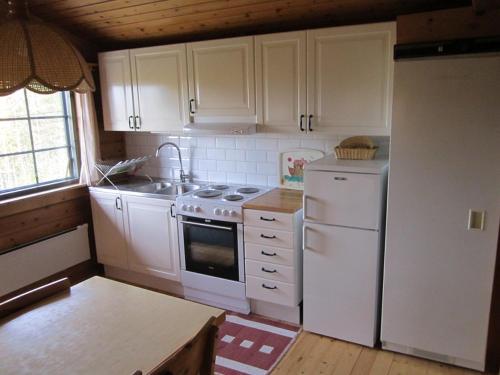 a kitchen with white cabinets and a white refrigerator at Stuga Sälen Kläppen 5 bäddar uthyres veckovis Söndag - Söndag in Sälen