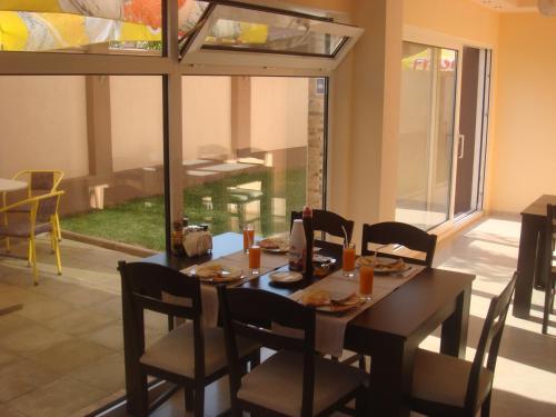 a dining room with a table and chairs and a window at Ivatea Family Hotel in Ravda