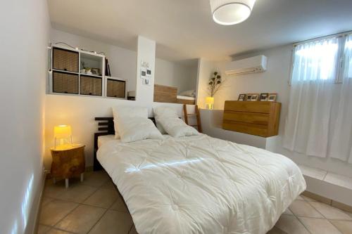 Un dormitorio con una gran cama blanca y una ventana en ☆ L'évasion En Provence ☆ Clim-Wifi-Netflix ☆, en Carnoux