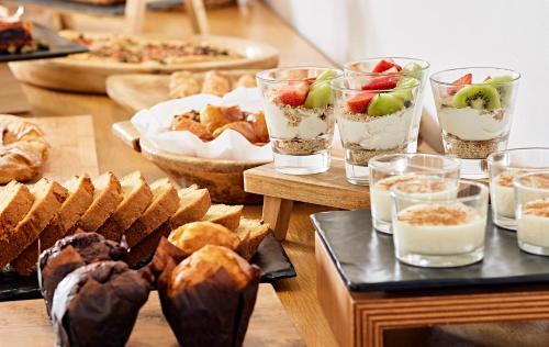 a table topped with different types of bread and desserts at Santa Maria Village Resort & Spa in Adamas