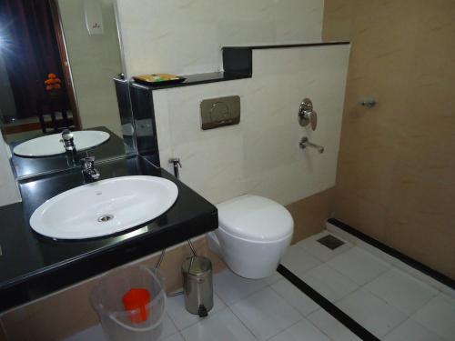 a bathroom with a sink and a toilet at Hotel Hiton in Perintalmanna