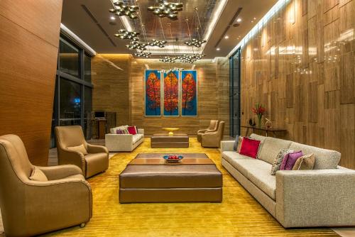 a living room with a couch and chairs and a table at Ascott Sentral Kuala Lumpur in Kuala Lumpur