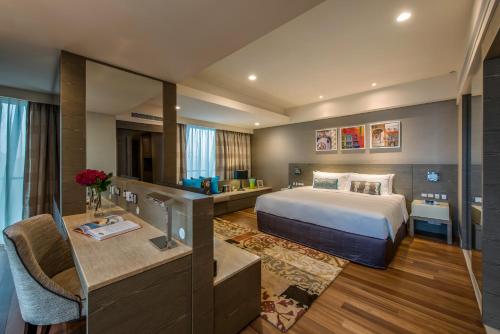 クアラルンプールにあるアスコット セントラル クアラ ルンプールのベッドとデスクが備わるホテルルームです。