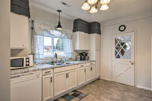 a kitchen with white cabinets and a sink and a window at 2 Mi to Lake Hartwell Charming Southern Cottage in Anderson