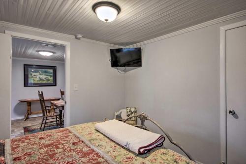 a room with a bed and a tv on the wall at 2 Mi to Lake Hartwell Charming Southern Cottage in Anderson