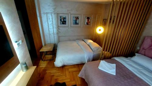 a bedroom with two beds and a table and a lamp at Apartman Planinski Kutak in Pale