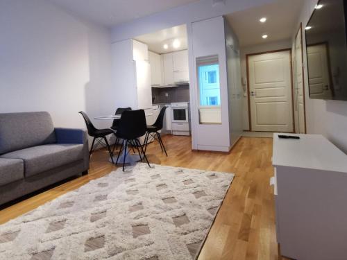 uma sala de estar com um sofá, uma mesa e cadeiras em Rovaniemi Cityhome Laura em Rovaniemi