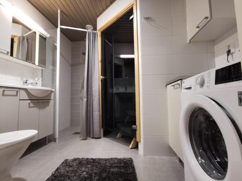 lavadero con lavadora y secadora en el baño en Rovaniemi Cityhome Laura, en Rovaniemi