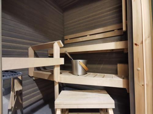 a sauna with wooden shelves and a bucket at Rovaniemi Cityhome Laura in Rovaniemi