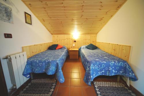 mały pokój z 2 łóżkami w pokoju w obiekcie Etna Rooftop Apartment w mieście Pedara